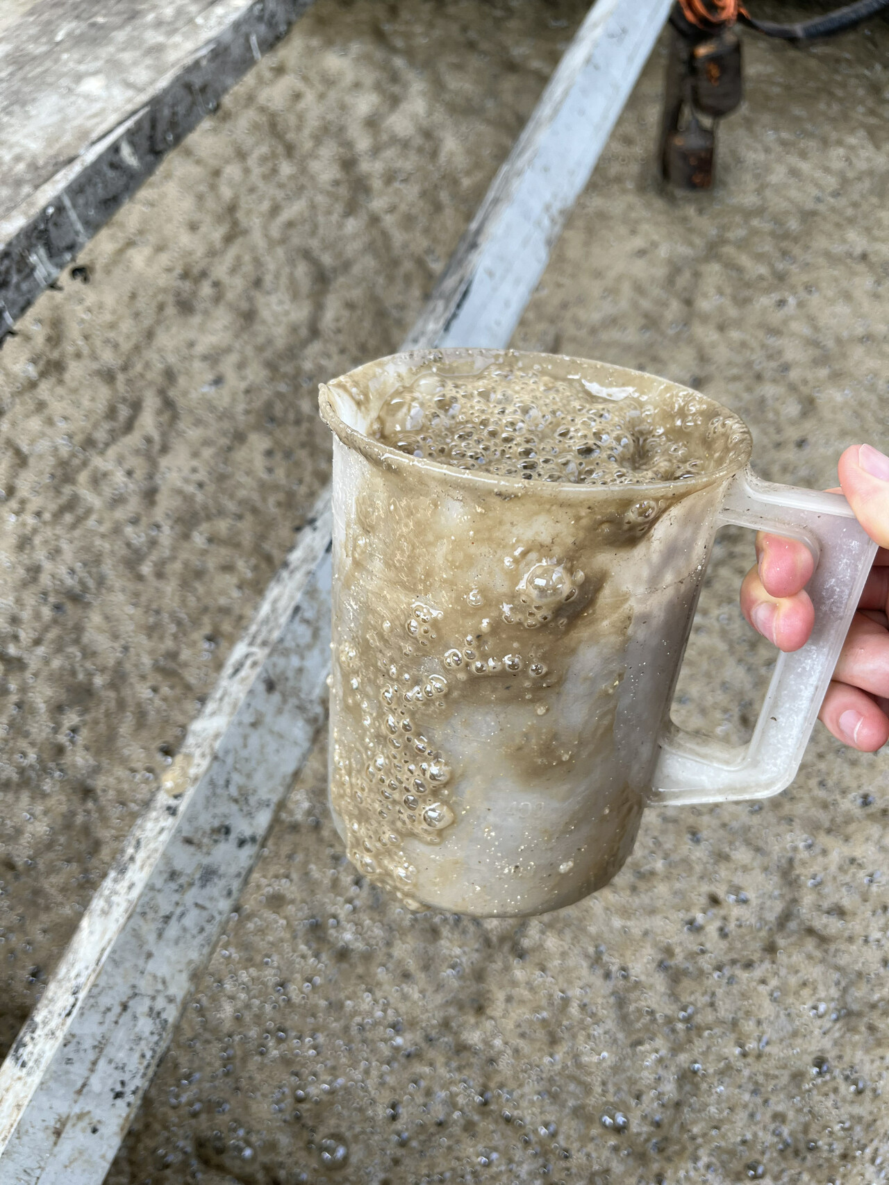 Slimy MBR foam and mixed liquor collected in a beaker